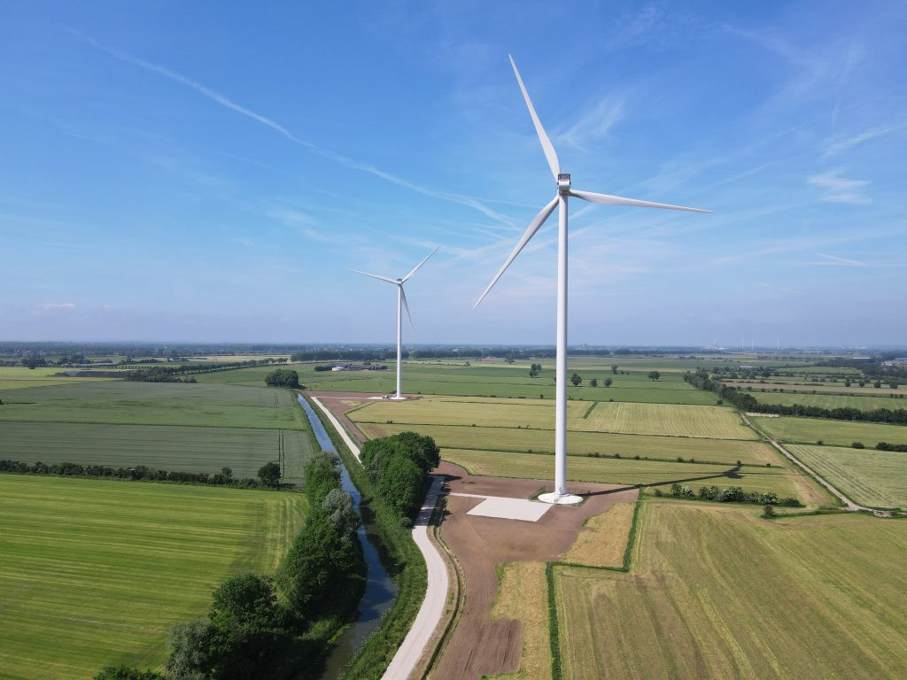 an aerial view of several wind turbines in a field.