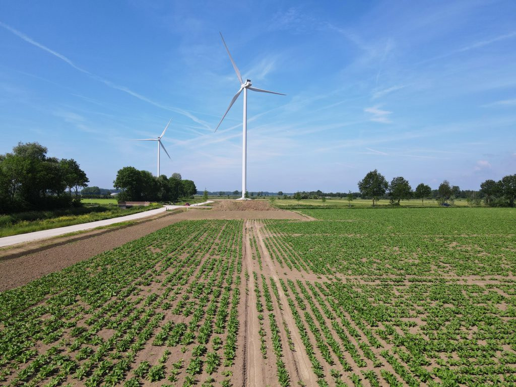 a large field with a windmill in the distance.